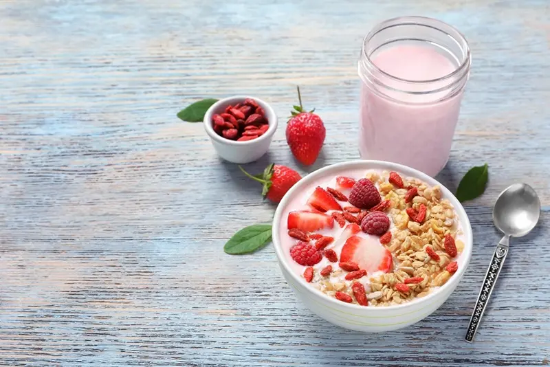 Granola con frutas en plato y batido en frasco de vidrio