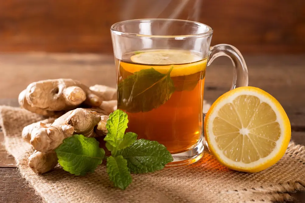 Té de jengibre con limón y menta en taza de vidrio
