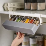 Organizador modular de especias con frascos de vidrio conteniendo condimentos y frutos secos naturales