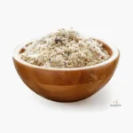 Harina de avellanas molida en bowl de madera sobre fondo blanco